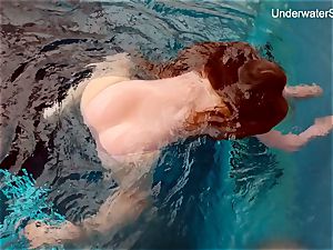 redhead Simonna demonstrating her assets underwater